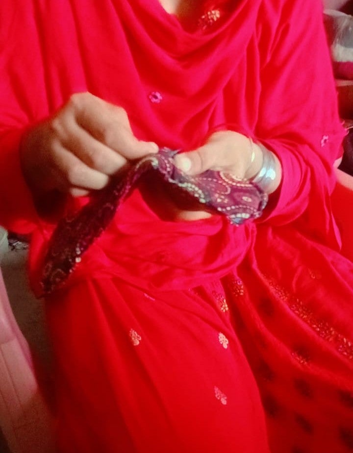 Farah Bibi stitches a reusable sanitary pad by hand, contributing to menstrual hygiene awareness and promoting sustainable and climate resilient practices in her community. 